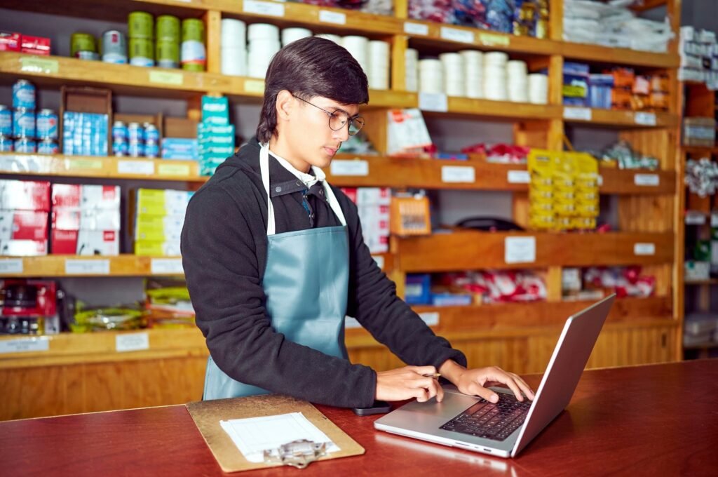 Small business owner building local SEO backlinks from a storefront laptop